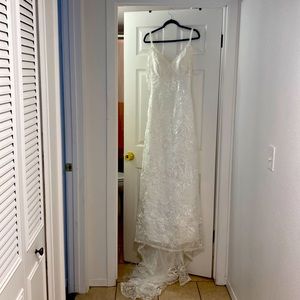 Beautiful white embroidered never worn wedding dress. Unique selves.